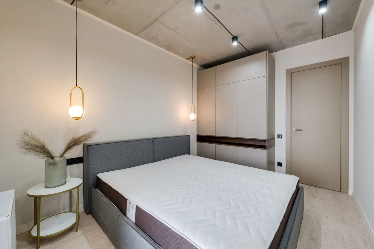 cozy small bedroom bedside pendant lighting brass detail styled