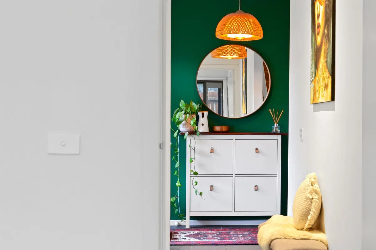 styled entryway bench with brass shoe tray underneath warm lighting